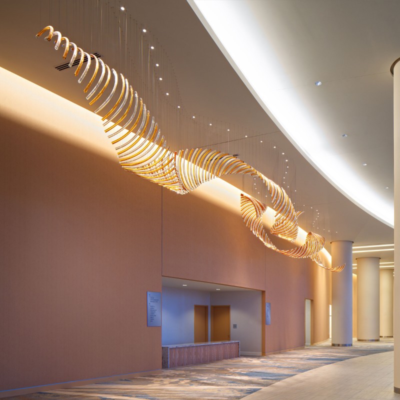 Modern hotel corridor decorated with long rotating glass chandelier